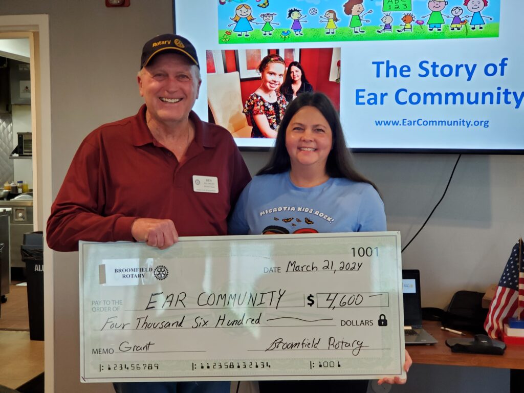 Ben Vagher of Broomfield Rotary Club awarding Melissa Tumblin of Ear Community a scholarship for local summer event